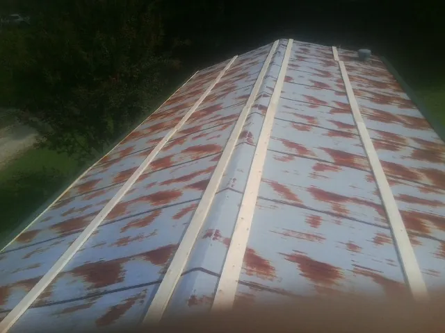 Rusted metal roof panels with new wood purlins before replacement — Storm Damage Roof Repair in Haugan by Roofing Brothers