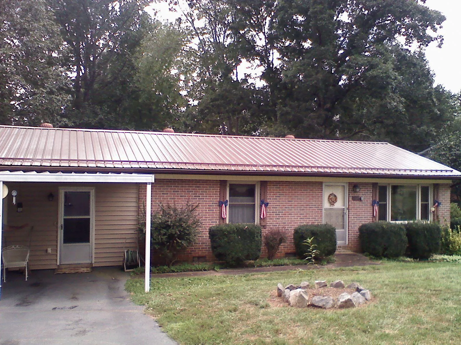 Bronze metal roof and carport on a brick ranch home — Roof Repair work by our crew in Haugan